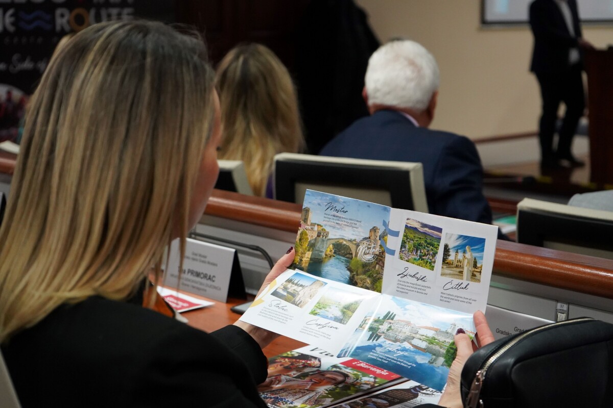 žena gleda kartu hercegovačkih vinskih regija