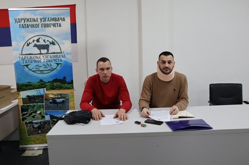 dva čovjeka sjede za stolom 
