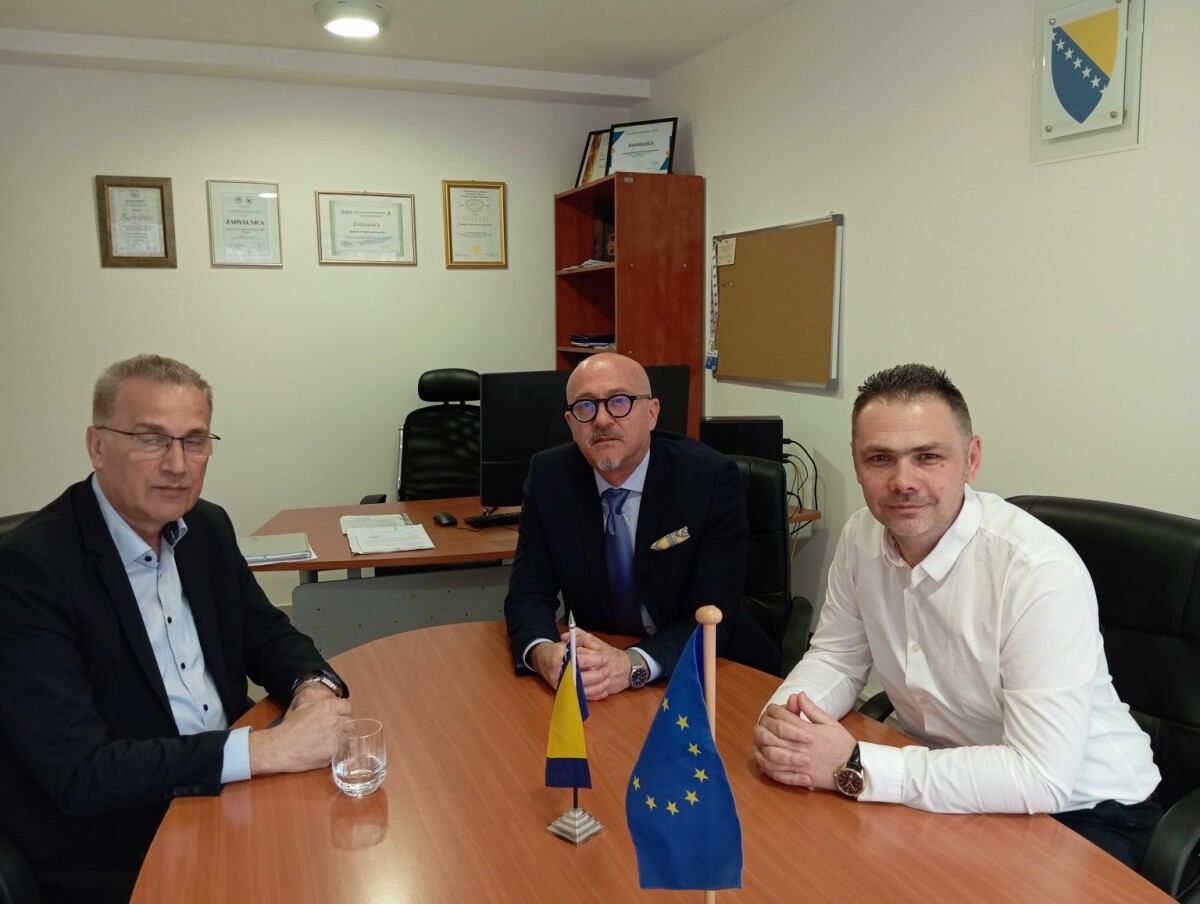 tri muškarca za stolom sjede, sastanak