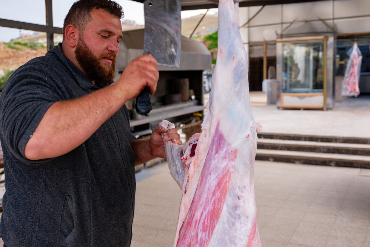 čovjek siječe svježe meso ovce