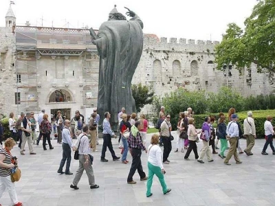 Inozemni turisti razgledavaju Dioklecijanovu palaču i spomenik Grgura Ninskog u Splitu
