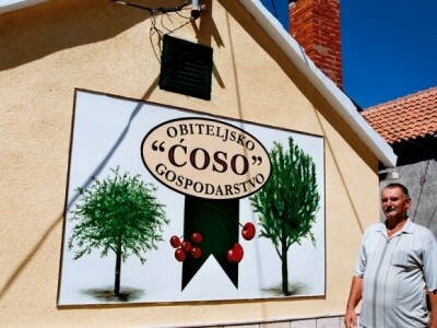 Josip Dundić (Ćoso) kod natpisa svog OPG-a u Goričaju (Grabovac, Šestanovac)