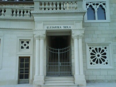 Klesarska škola u Pučišćima (ulazna vrata zagrljena stupovima, rozetama...) Klesarska škola u Pučišćima (ulazna vrata zagrljena stupovima, rozetama...)