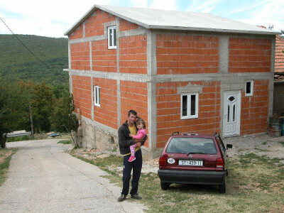 Slavko Vuica s kćerkom u naručju ispred njihove noviizgrađene obiteljske kuće u Cisti Velikoj